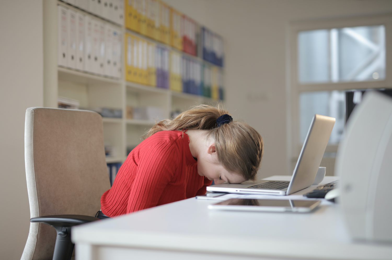 tired woman with head on desk