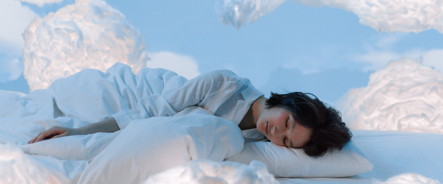 woman laying on pillow surrounded by clouds