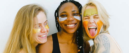 three smiling women with facemasks