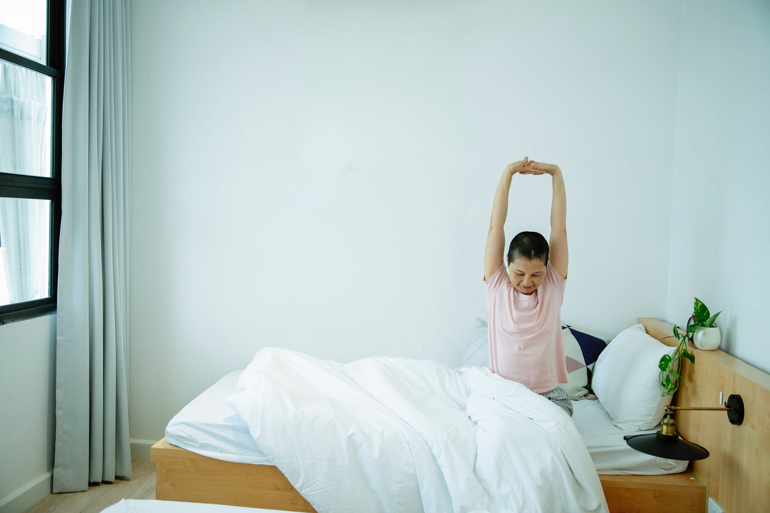 woman waking up stretching arms above head